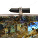 Close up of Natural labradorite gemstone clutch with quartz crystal knob and silver brass frame