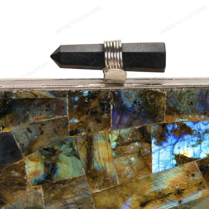 Close up of Natural labradorite gemstone clutch with quartz crystal knob and silver brass frame