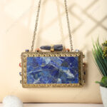 Rare lapis lazuli gemstone handbag with side-adorned gold frame and quartz crystal knob