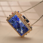 Rare lapis lazuli gemstone handbag with side-adorned gold frame and quartz crystal knob