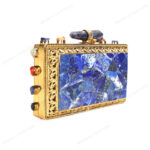 Rare lapis lazuli gemstone handbag with side-adorned gold frame and quartz crystal knob