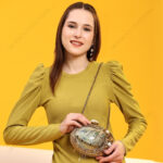 Lifestyle shout of Gemstone-Embellished Paua Abalone Seashell Clutch with Gold Frame & Metal chain strap for shoulder carry