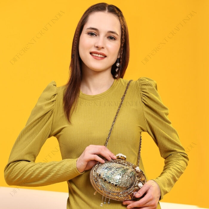 Lifestyle shout of Gemstone-Embellished Paua Abalone Seashell Clutch with Gold Frame & Metal chain strap for shoulder carry