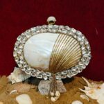 Front view of Rhinestone-Embellished Bag Shell Encircling the White Clam Seashell with Tassel Chain