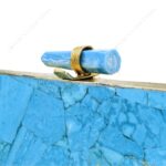 Closeup of Turquoise gemstone clutch purse with quartz crystal knob and gold brass frame