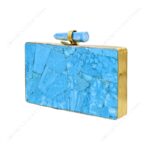 Angle view of Turquoise gemstone clutch purse with quartz crystal knob and gold brass frame