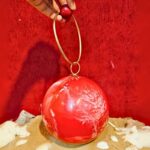 Round Red Resin Ball Clutch with Gold-Tone Circular Metal Handle for a Statement Look